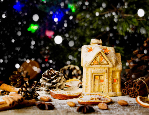 Χριστουγεννιάτικη κάρτα με μικρό παιχνίδι σπίτι και διακόσμηση σε ρουστίκ ξύλινα πίνακα, επιλεκτική εστίαση - Φωτογραφία, εικόνα