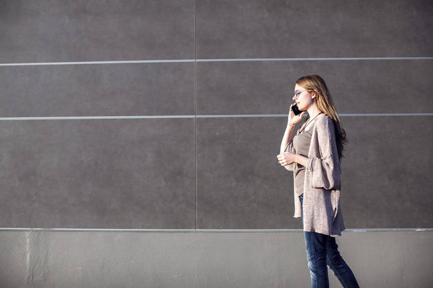 Young woman talking phone on street - Фото, изображение