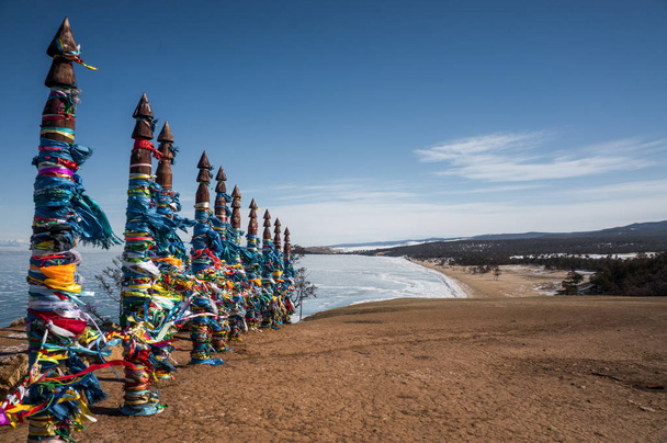 деревянные столбы с разноцветными лентами
 - Фото, изображение