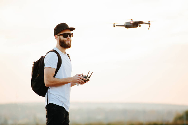 Man operating the drone by remote control and having fun  - Foto, imagen