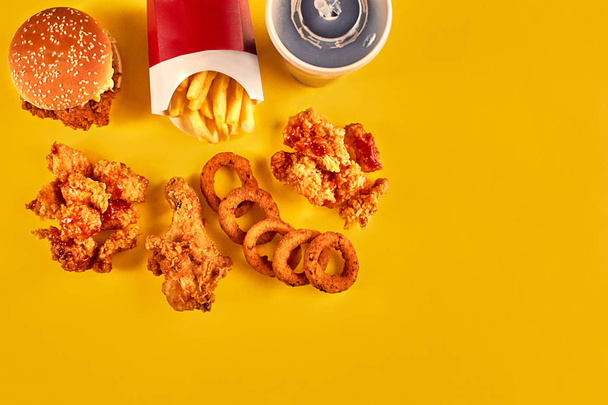 Pohled shora hamburger, hranolky a smažené kuře na žlutém podkladu. Prostor pro váš text zkopírovat. - Fotografie, Obrázek