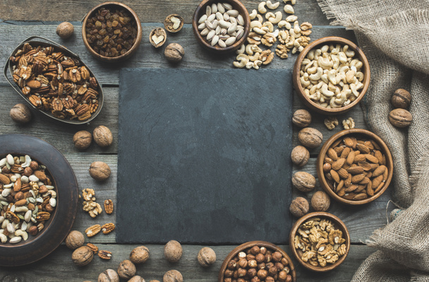 various nuts and slate board - Photo, Image