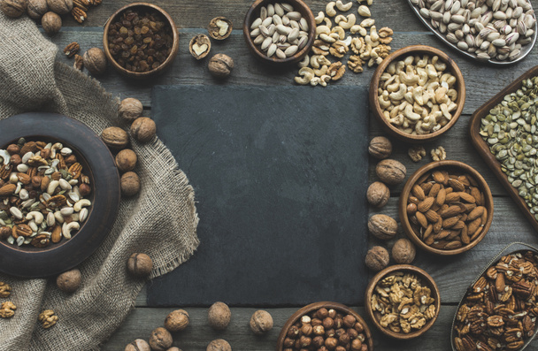 nuts in bowls and slate board - Zdjęcie, obraz