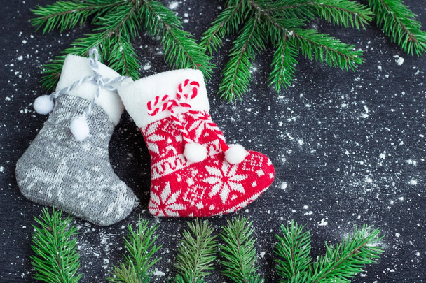 Two Christmas stockings on snowbound black background with fir b - Photo, Image