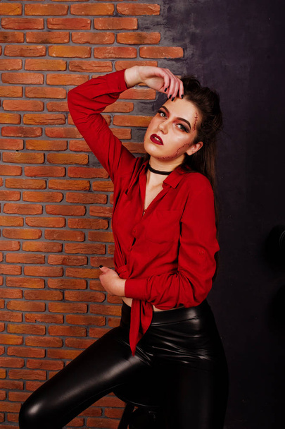 Black girl in red shirt and leather pants with bright make-up po - Valokuva, kuva