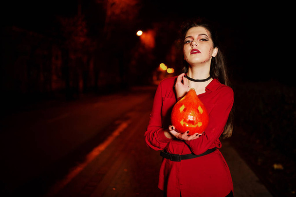 Black girl in red shirt and bright make-up with pumpkin at hands - Valokuva, kuva