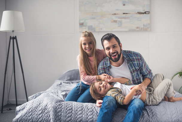 father and kids resting on bed - Zdjęcie, obraz