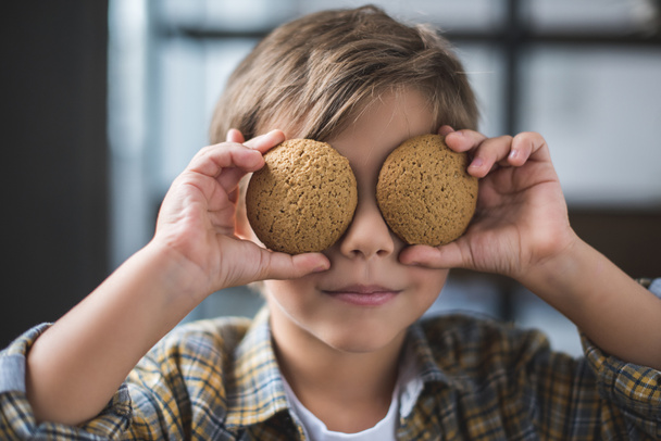 pikkupoika pitelee keksejä
 - Valokuva, kuva
