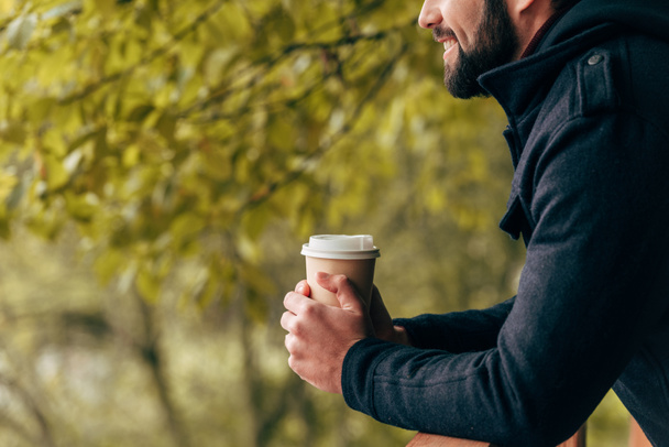 man with paper cup in park - Photo, Image