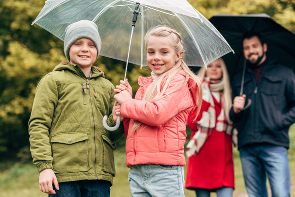 pais e filhos com guarda-chuvas
 - Foto, Imagem