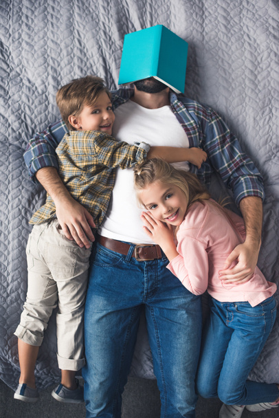 family lying on bed - Foto, afbeelding