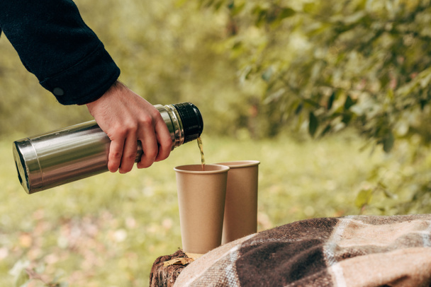 man pouring tea from thermos - Photo, Image