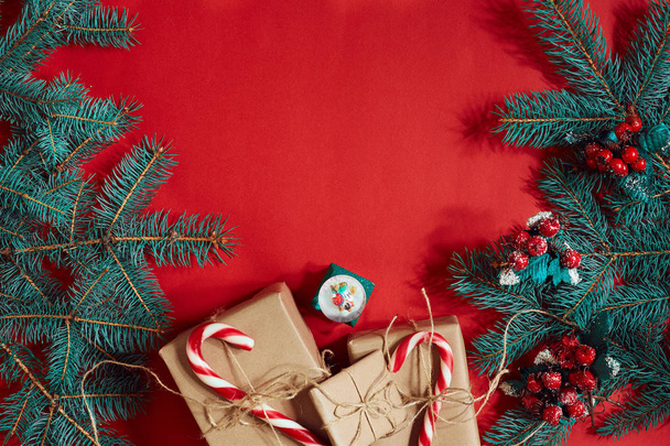 Rama de abeto y caja de regalo sobre fondo rojo
 - Foto, Imagen