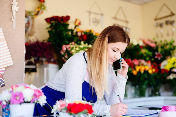 Mulher proprietária de florista loja recebendo ordens
 - Foto, Imagem