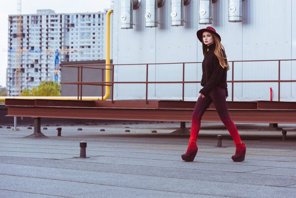 woman in stylish outfit walking on roof - Photo, Image