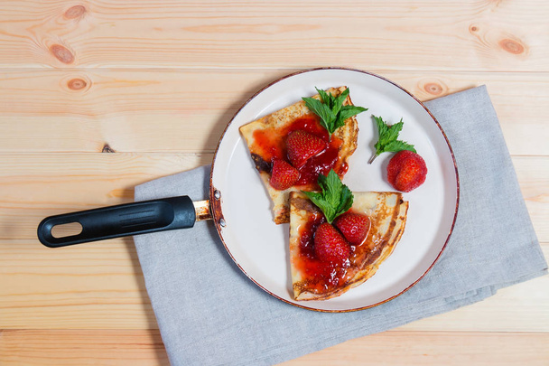 Γλυκιά κρέπα με φρέσκες φράουλες και μαρμελάδα στο τηγάνι  - Φωτογραφία, εικόνα