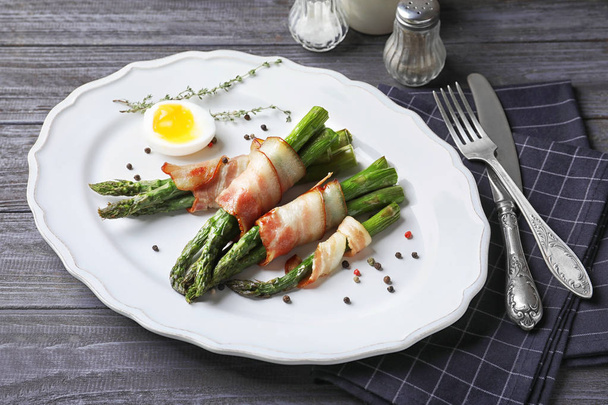 Plate with bacon wrapped asparagus on table - Foto, afbeelding