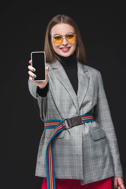 woman in autumn outfit showing smartphone  - Foto, imagen