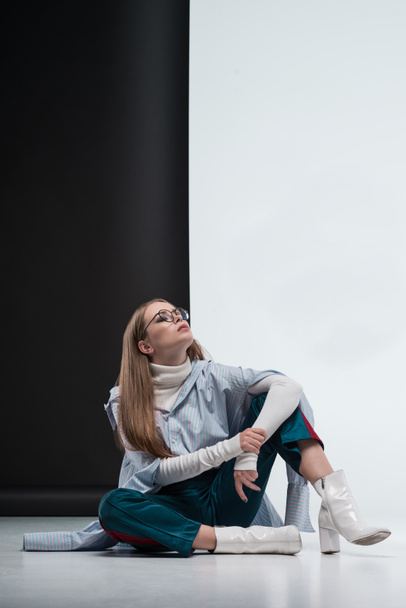 woman in stylish outfit sitting on floor - Photo, Image