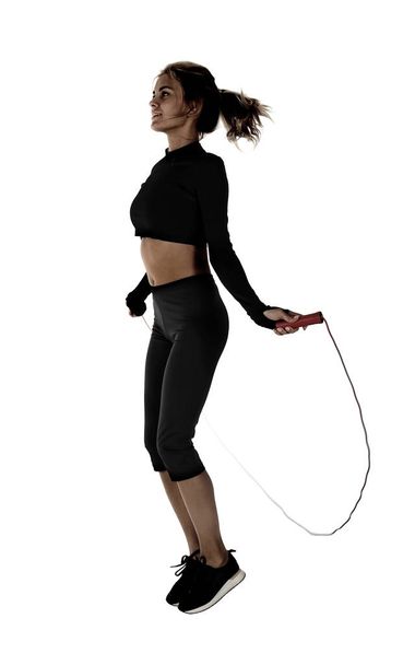 Young woman with jumping rope on white background - Foto, Imagen