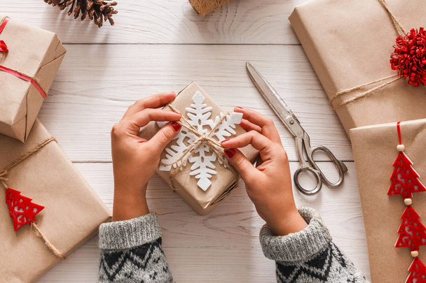 Womans hands wrapping christmas holiday present with craft twine - Photo, Image