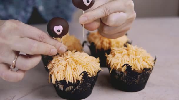 Decorating funny cupcake with chocolate eyes. Muffin with Halloween concept - Séquence, vidéo