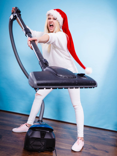 Angry girl in santa helper hat with vacuum cleaner - Photo, image