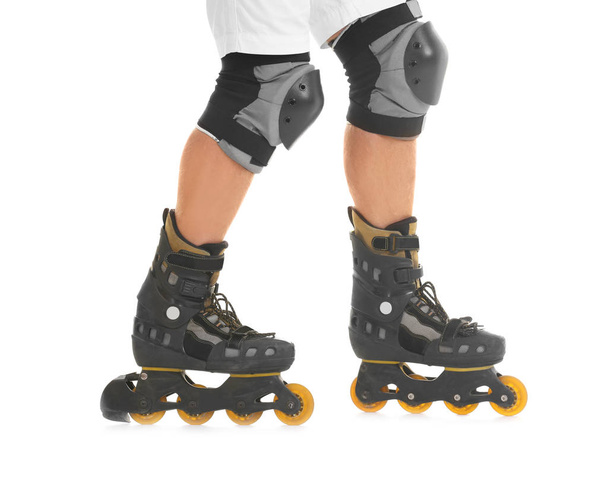 Legs of young man on roller skates against white background - 写真・画像