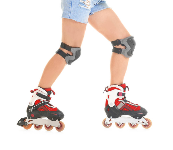 Legs of young woman on roller skates against white background - 写真・画像