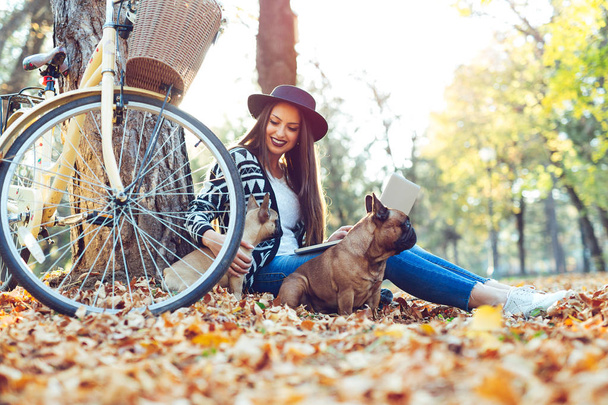 Gyönyörű nő és kutyája, őszi parkban - Fotó, kép