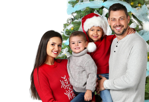 Ευτυχισμένη οικογένεια με στολισμένο χριστουγεννιάτικο δέντρο σε λευκό φόντο - Φωτογραφία, εικόνα