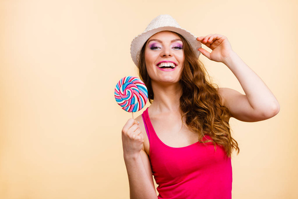 Woman holds colorful lollipop candy in hand - Fotó, kép