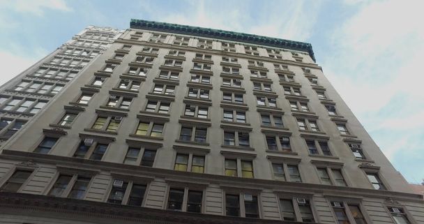 Vista vertical do prédio típico de escritórios em estilo NYC durante o dia
. - Foto, Imagem