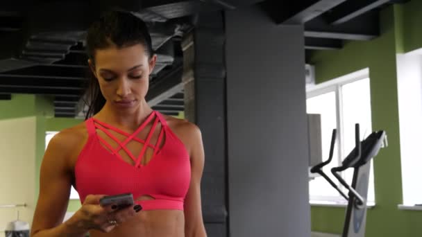 fitte athletische Mischlingshündin läuft SMS in Sporthalle am Telefon - Filmmaterial, Video