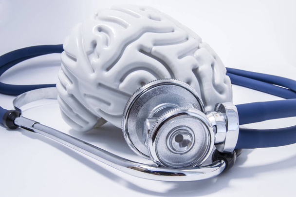 die Figur des menschlichen Gehirns mit einem Stethoskop oder Phonendoskop um ihn herum. Bild für neurologische Untersuchungen oder Befragungen - Foto, Bild