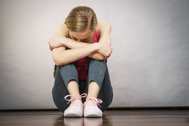 Sad depressed young teenage girl sitting by wall - Valokuva, kuva