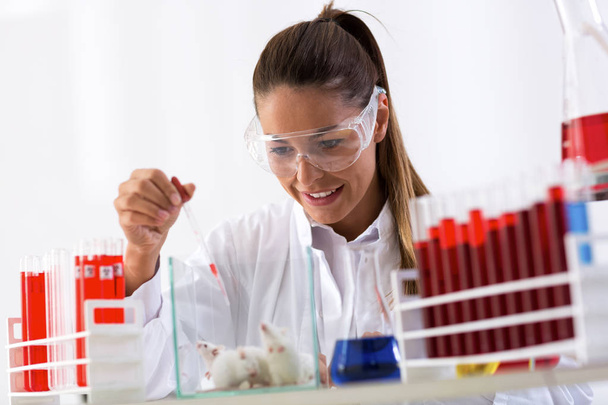 Woman chemist testing new formula on mouses - Фото, изображение