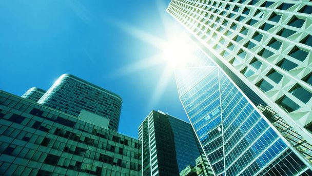 Pilvenpiirtäjä lasi julkisivut valoisa aurinkoinen päivä auringonsäteet sininen taivas. Moderneja rakennuksia Pariisin liikealueella La Defense. Talous, rahoitus, yritystoiminnan käsite. Alhaalta ylös näkymä
 - Valokuva, kuva