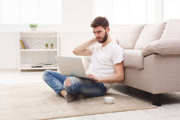 Jeune homme à la maison avec ordinateur portable sentir la douleur
 - Photo, image