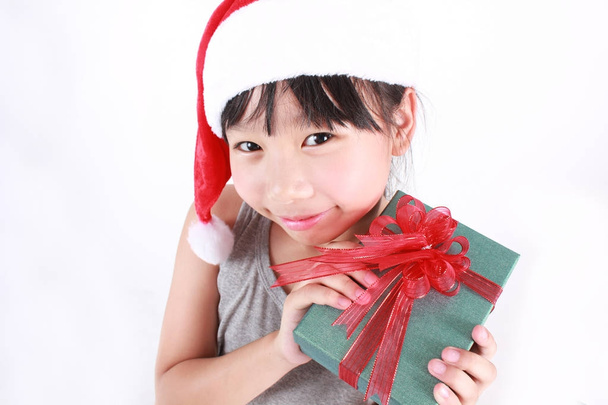 Portrait of little cute asian girl wearing red christmas hat holding boxes of gift isolated on white background  - Fotoğraf, Görsel
