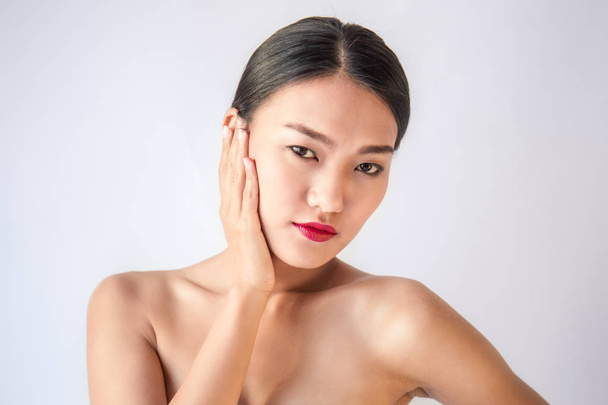 retrato de belleza joven asiático mujer con mano en cara posando en cámara aislado en blanco fondo
 - Foto, imagen