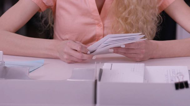 Womans kädet iteroida kirjaimet kirjekuorissa. Sulje kirjekuoret, jotka ovat iäkkään naisen käsissä. Sihteeri sulkeminen kasa kirjekuoria
 - Valokuva, kuva
