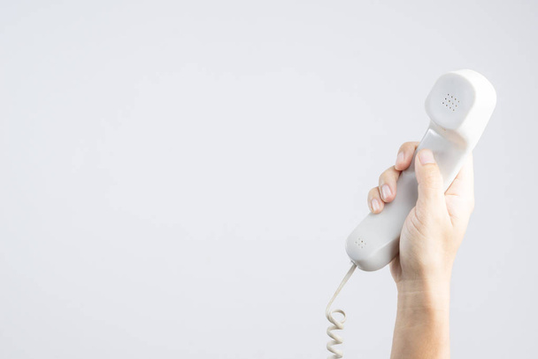 Hand holding home or office telephone with line on white background - Zdjęcie, obraz