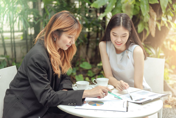 Deux femmes d'affaires discutant sur la paperasse graphique sur la table
. - Photo, image