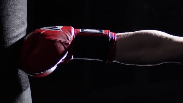 パンチング バッグ - 男と A タトゥー ボクシングの暗い背景を持ついくつかのキックの練習戦闘機。キック、暗い背景にサンドバッグ。ジムで重量を量る黒パンチング バッグ - 写真・画像