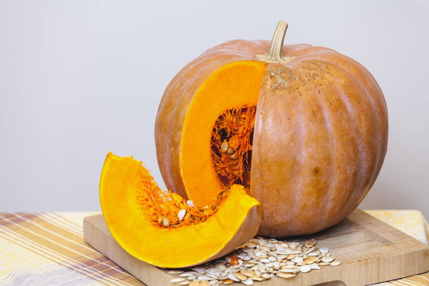beautiful piece of ripe pumpkin is next to round pumpkin - Foto, afbeelding