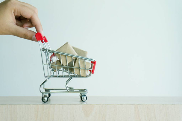 Woman hand forefinger pushing small shopping cart with Internet  - Foto, Imagen