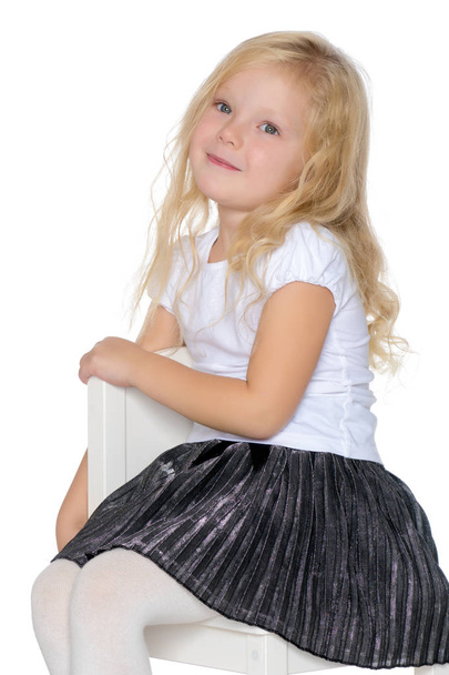 Little girl is sitting on a stool - Zdjęcie, obraz