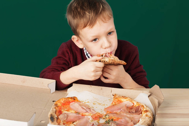 Gyermekek olasz pizzát enni a kávézóban. Iskola fiú eszik piz - Fotó, kép