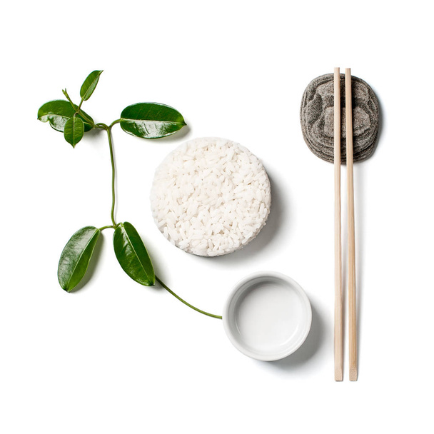 White rice, chopsticks and a branch of a young plant on a white  - Fotografie, Obrázek